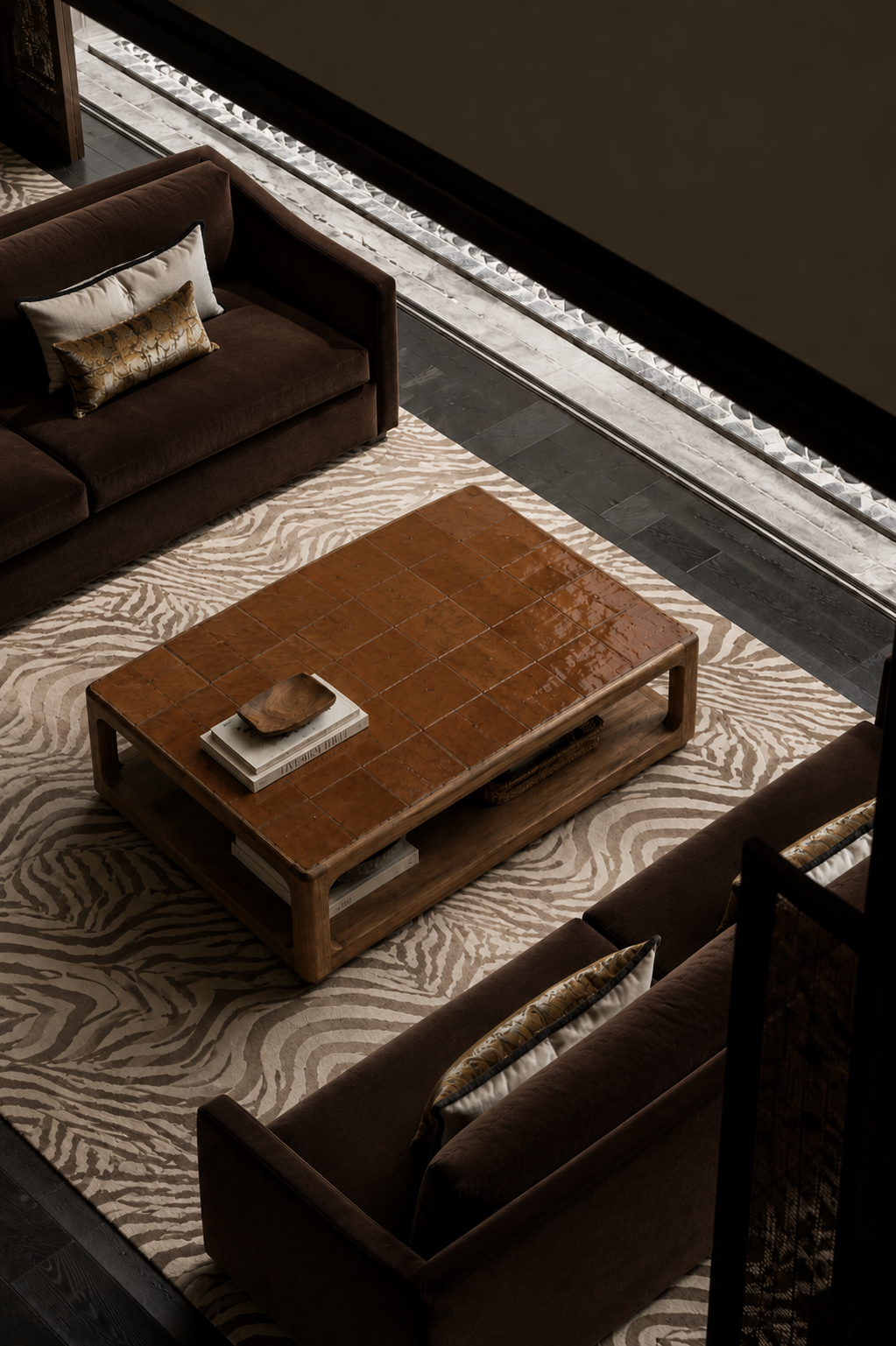 A modern rectangular wooden coffee table with a glossy brown ceramic tile top and open lower shelf, styled in a contemporary living room with dark brown sofas and a patterned beige rug.