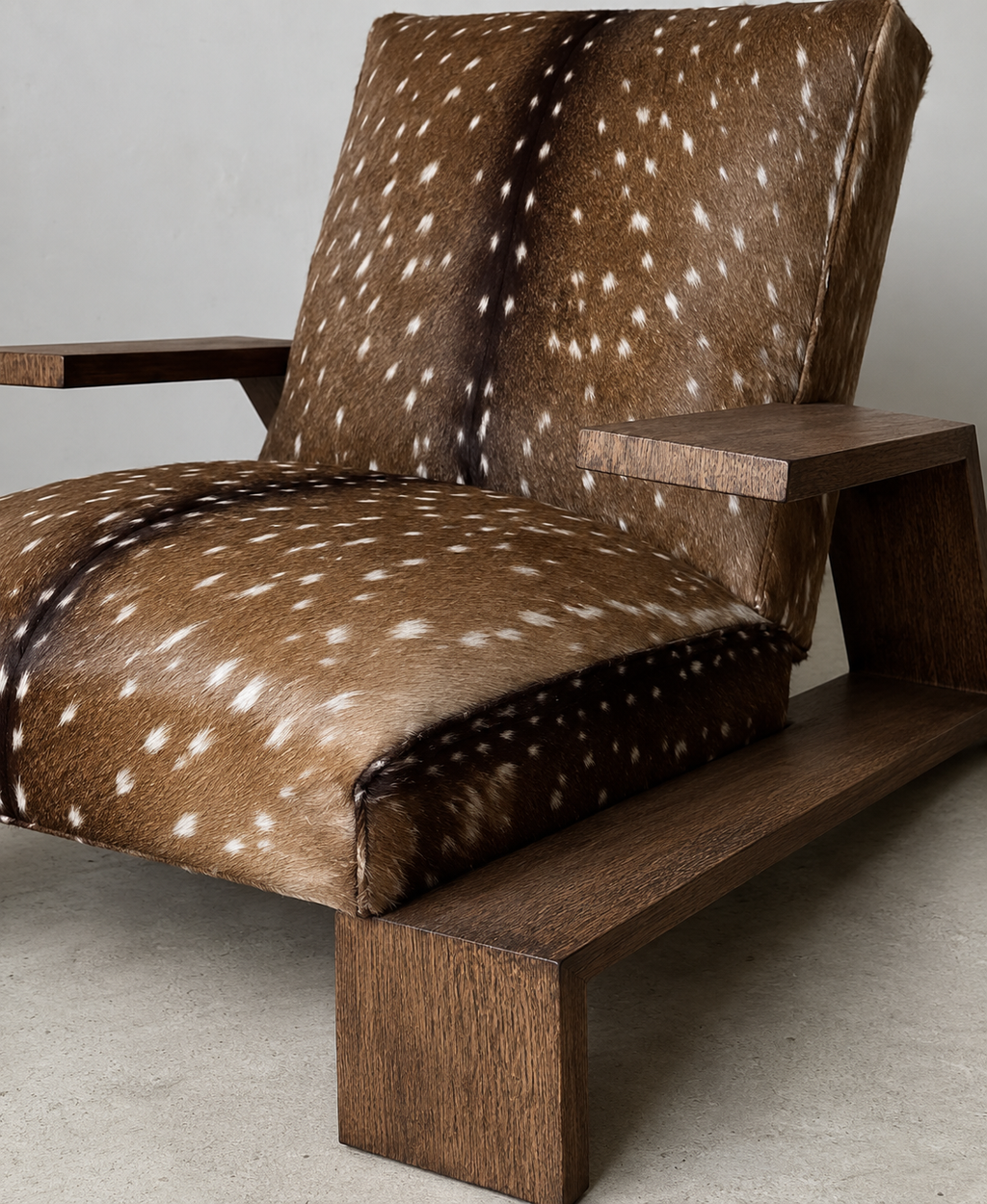 A modern lounge chair with a dark brown wooden frame and upholstery featuring brown deer animal hide with white spots, set against a neutral gray background.